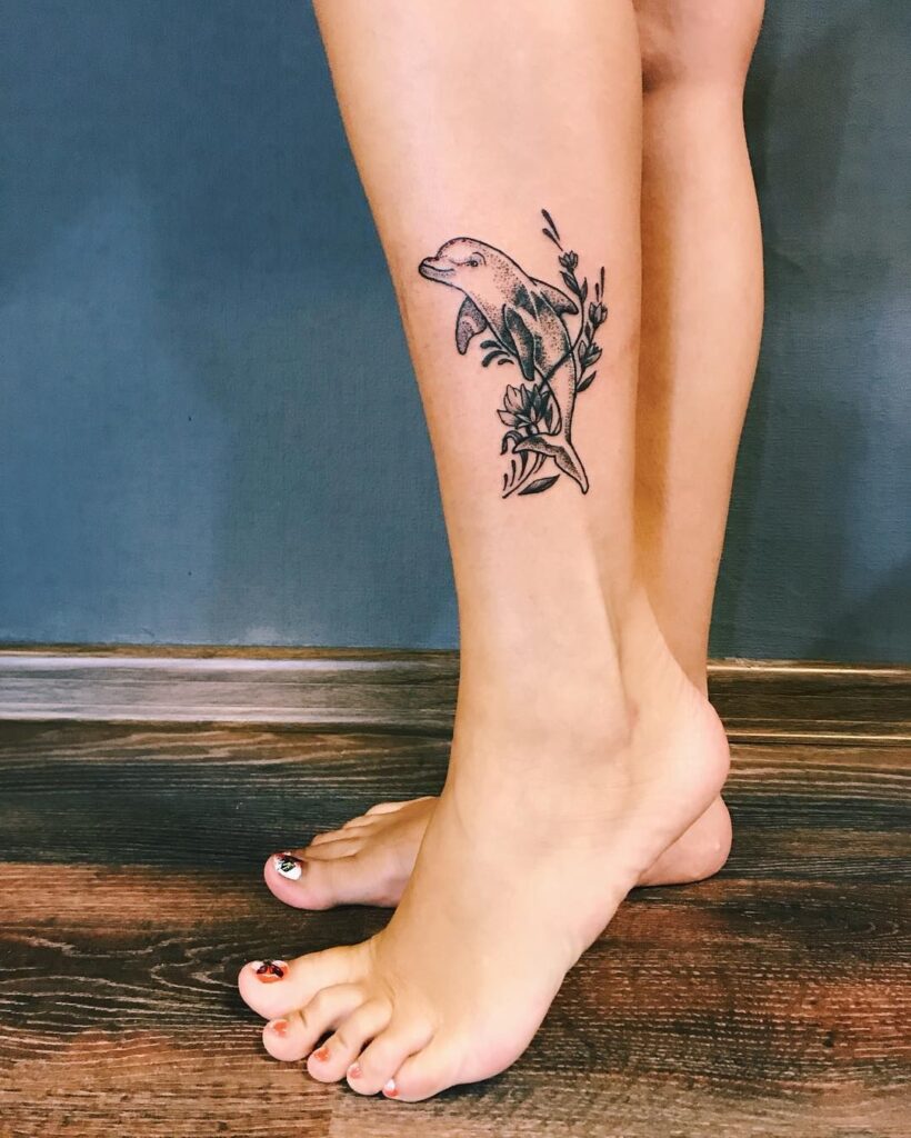 Dolphin tattoo on the shin for women