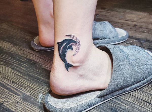 Tattoo of a dolphin on an ankle for women