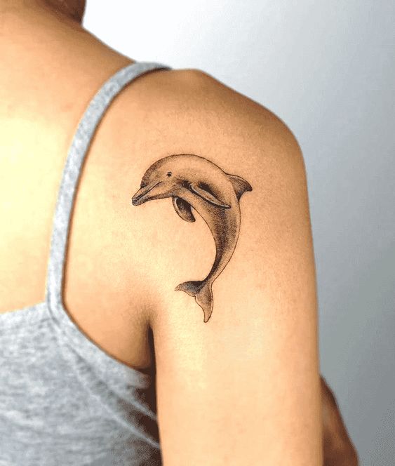 Tattoo of a dolphin on the shoulder for women