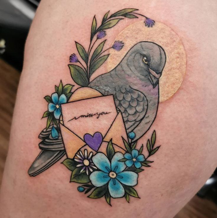 Color tattoo of a dove with flowers on the leg for women