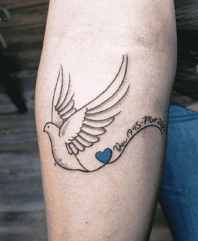 Tattoo of a dove with an inscription on the calf for women