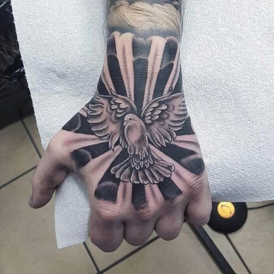 Large tattoo of a dove on the hand for men