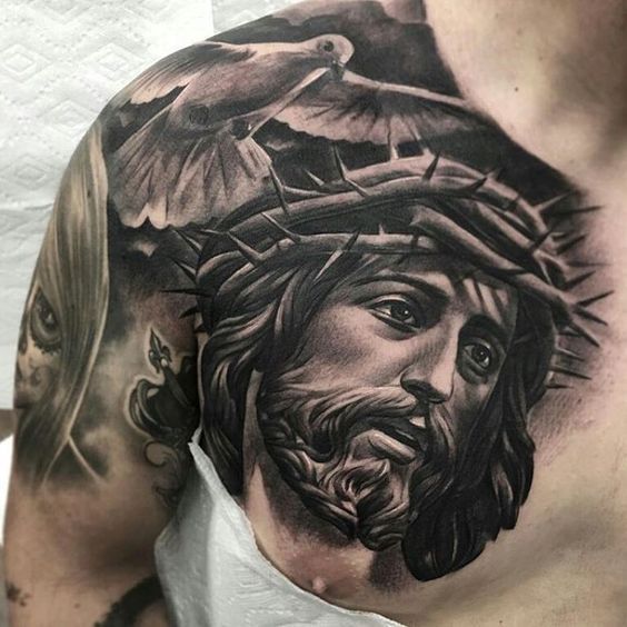 A large tattoo of a dove and God on the chest for men