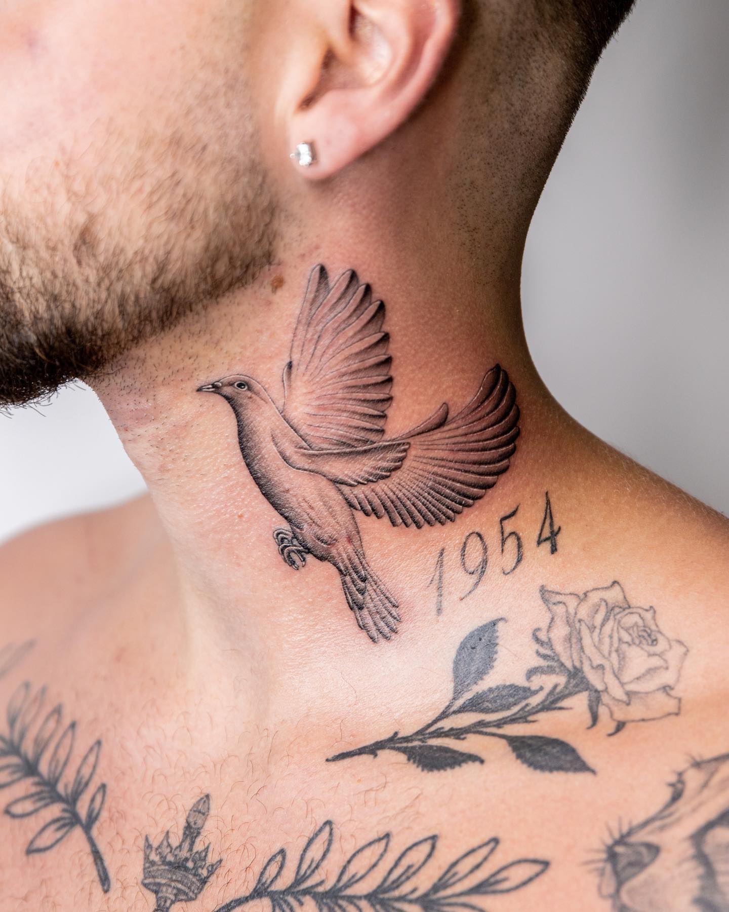 Large tattoo of a dove on the neck for men