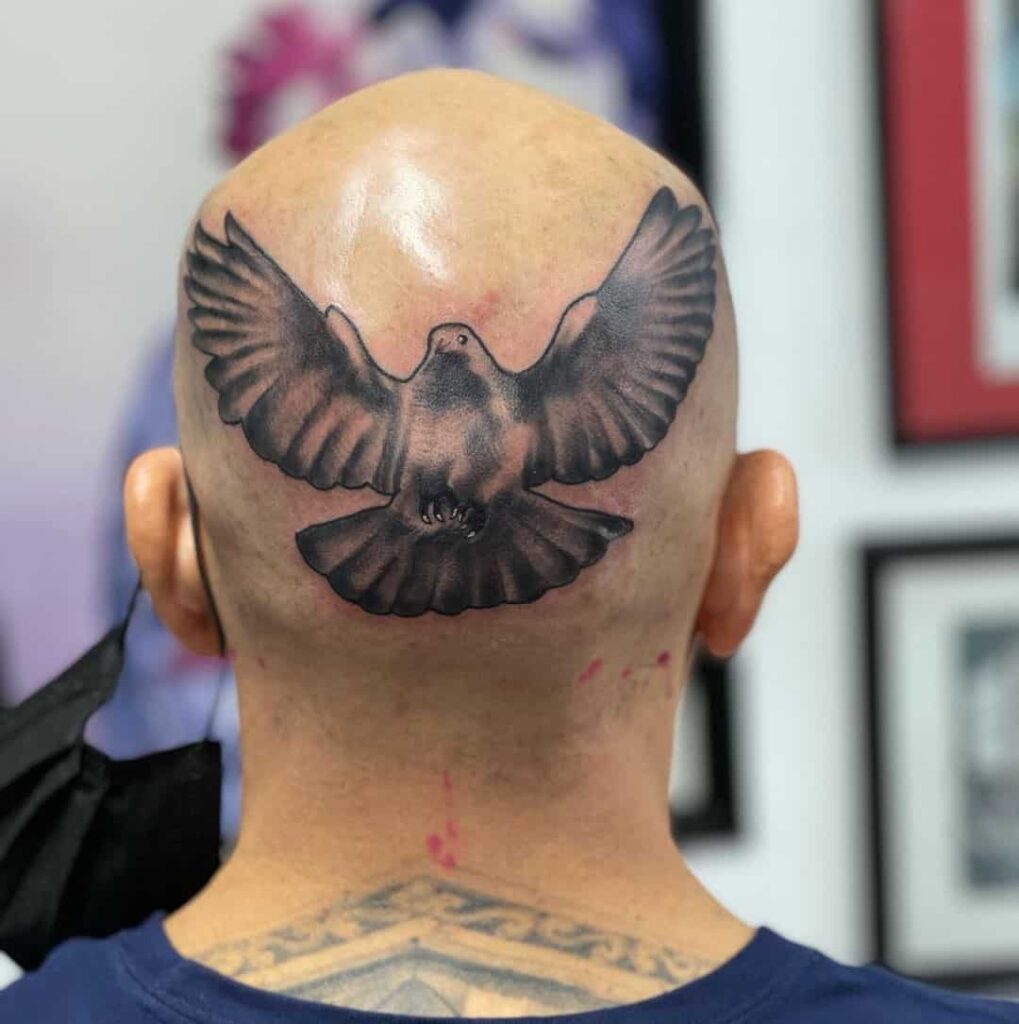 Large tattoo of a dove on the head for men