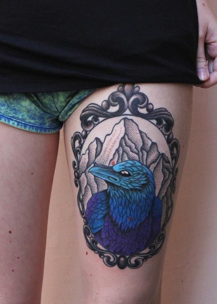 Color tattoo of a raven on the thigh for women