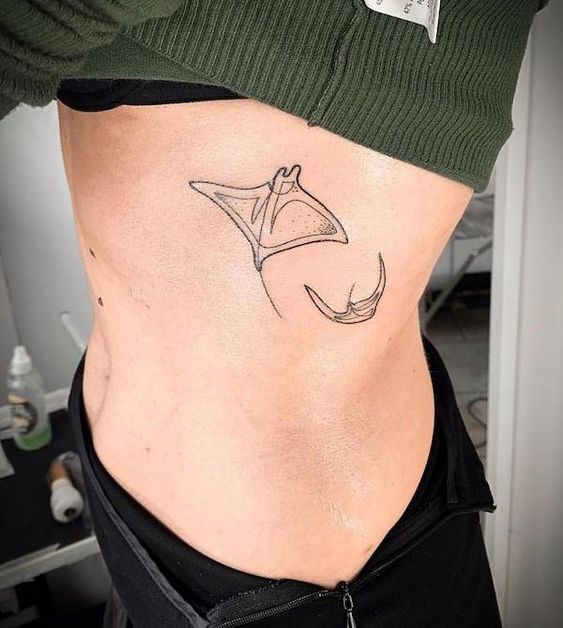 Tattoo of two stingrays on the side for women