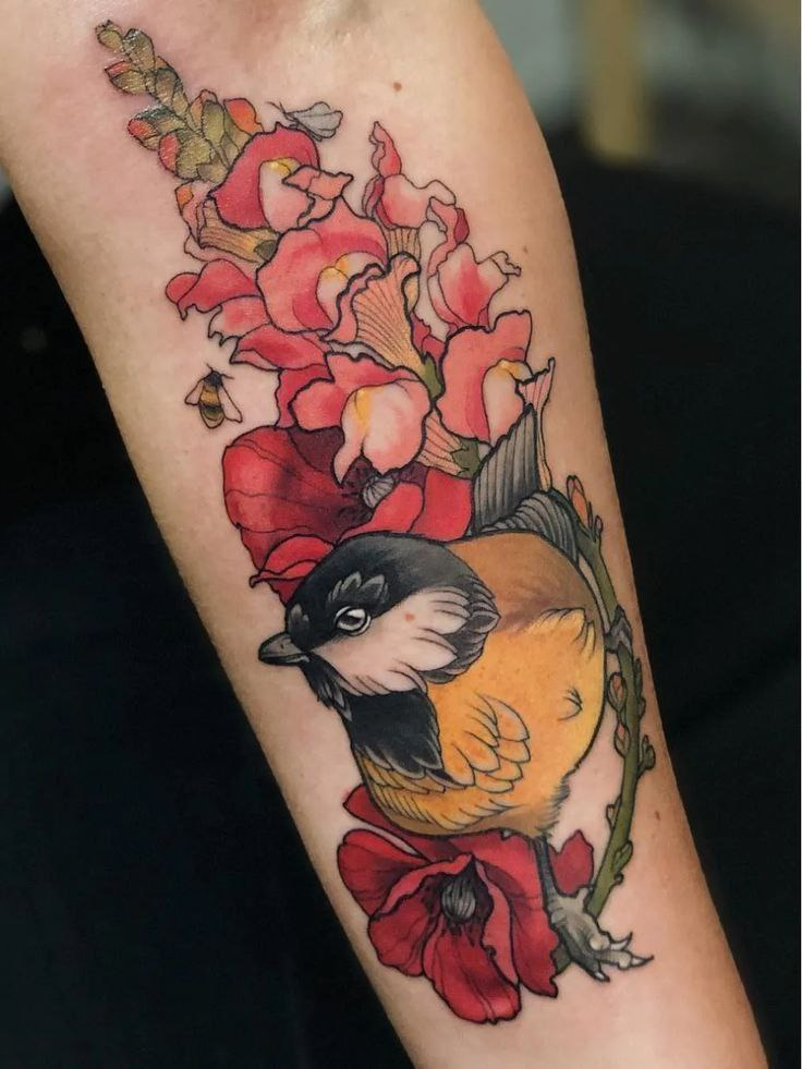 Color tattoo of a tit with flowers on the forearm for women