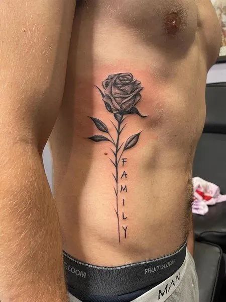 Large rose tattoo with inscription on the side for women