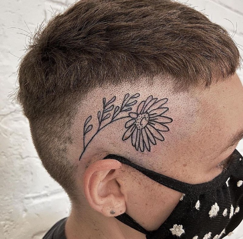 Tattoo of a daisy on the head for men