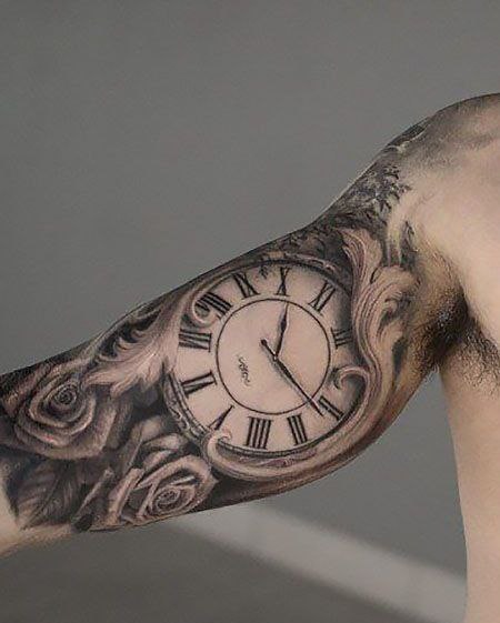 Large watch tattoo on the biceps for men