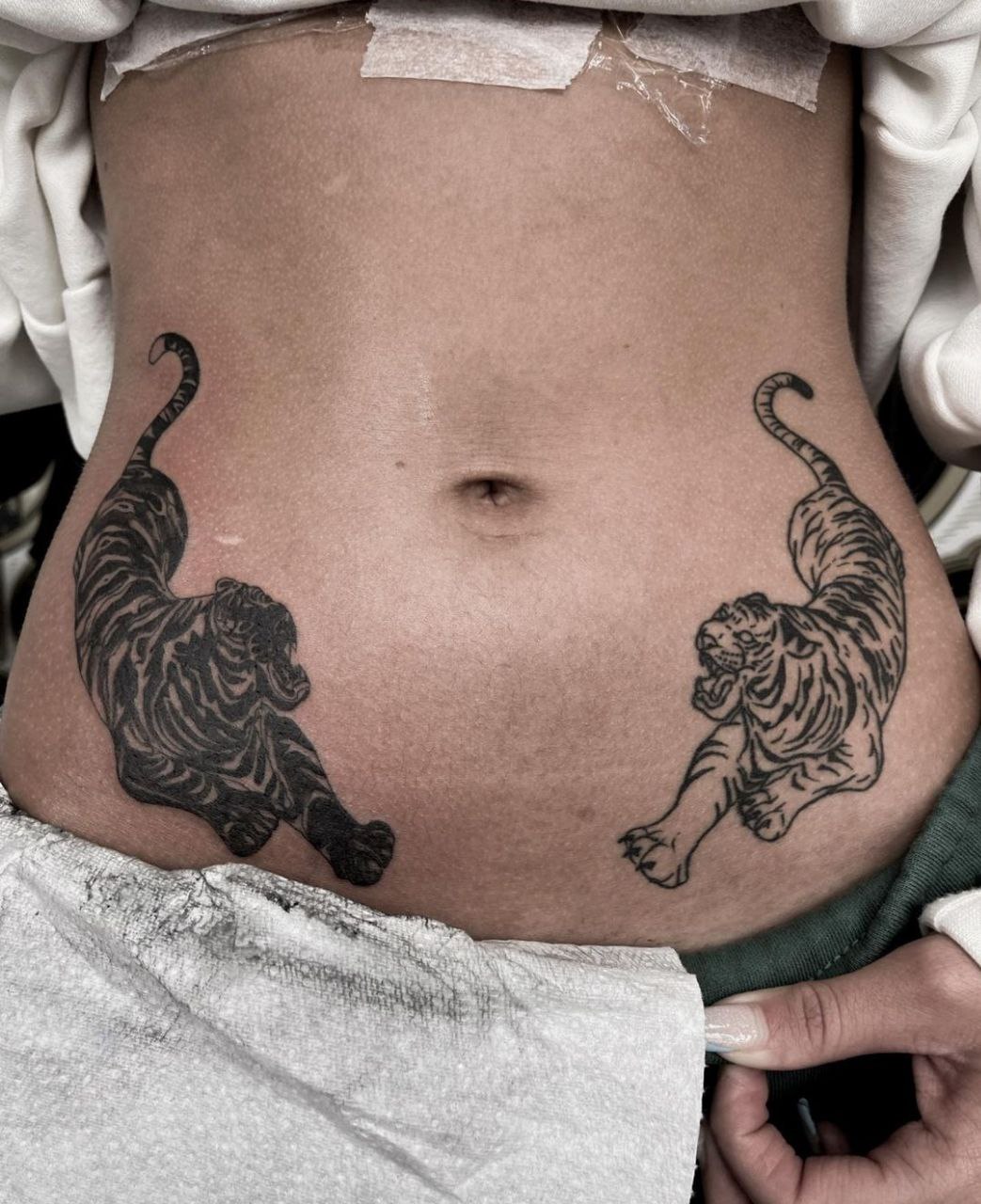 Large tattoo of two tigers on the abdomen for women