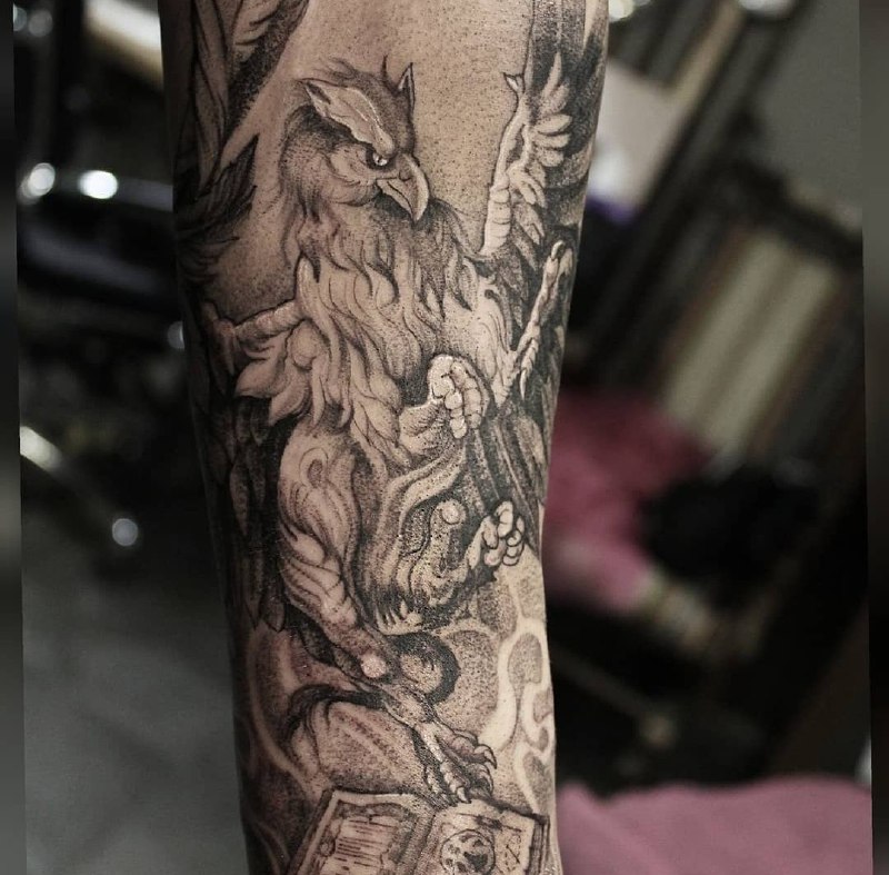 Large griffin tattoo on the arm for men