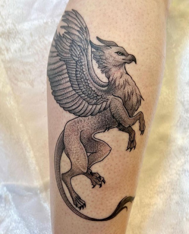 Large griffin tattoo on the shin for men