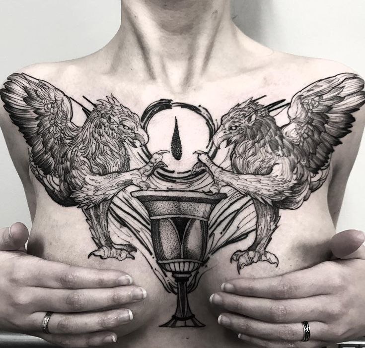 Large tattoo of two griffins on the chest for women