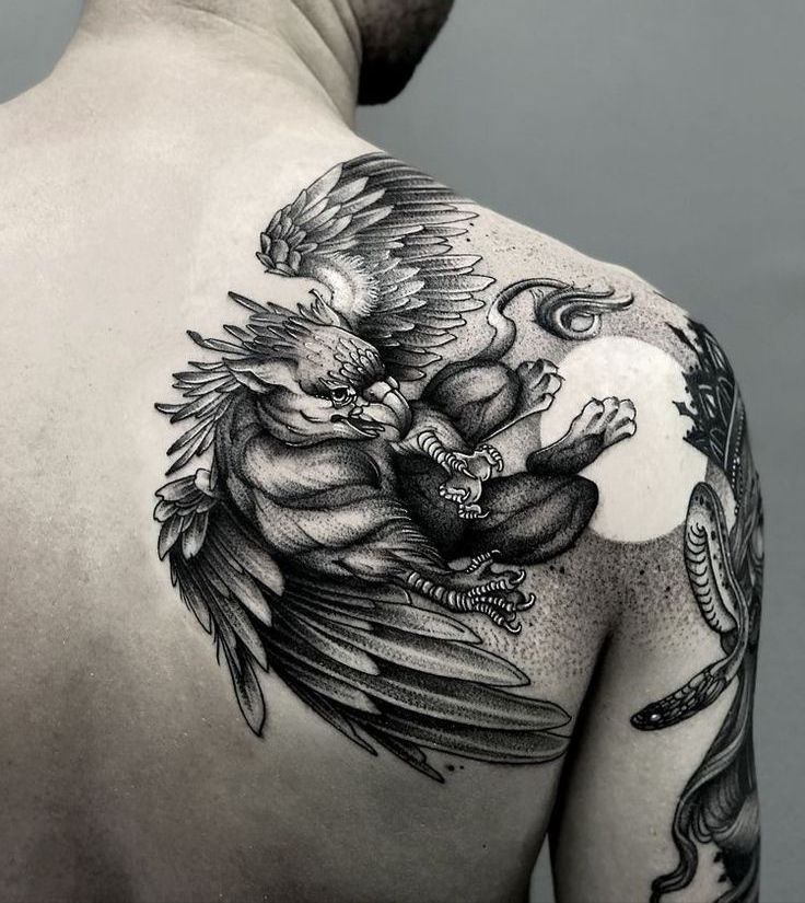 Tattoo of a griffin on the shoulder blade for men