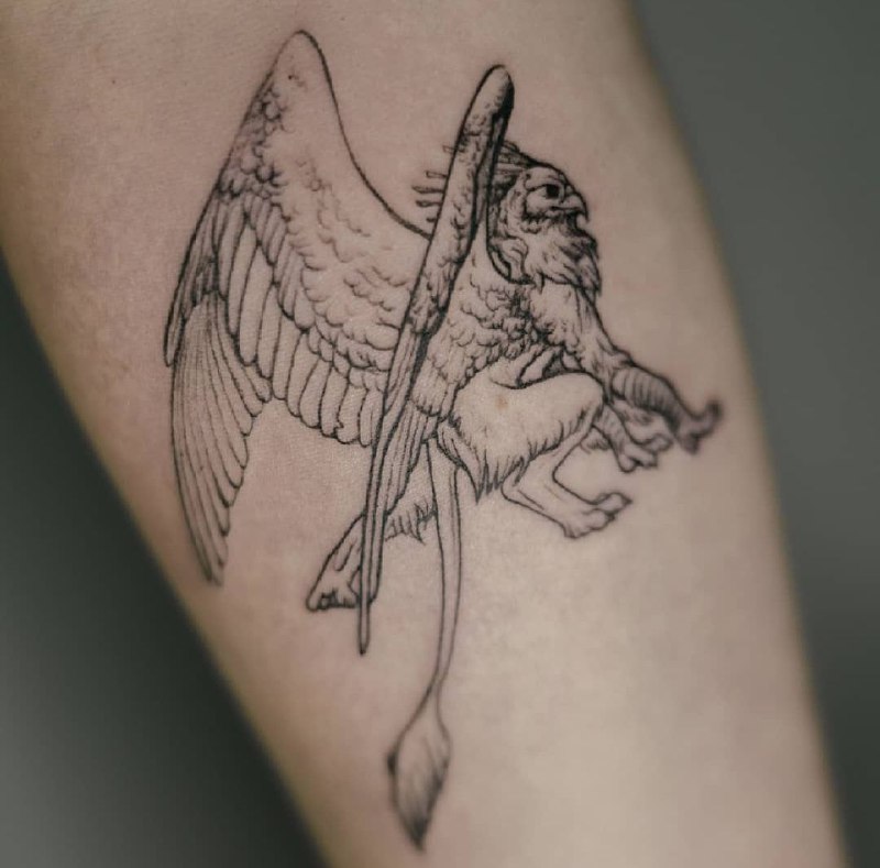 Tattoo of a griffin on the arm for women