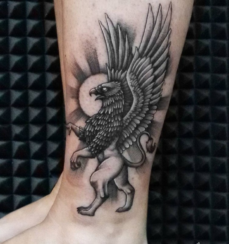 Tattoo of a griffin on the shin for men