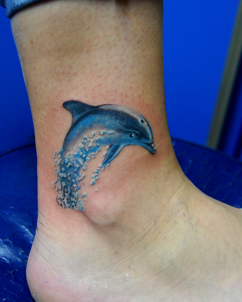 Colorful dolphin tattoo on the leg for women