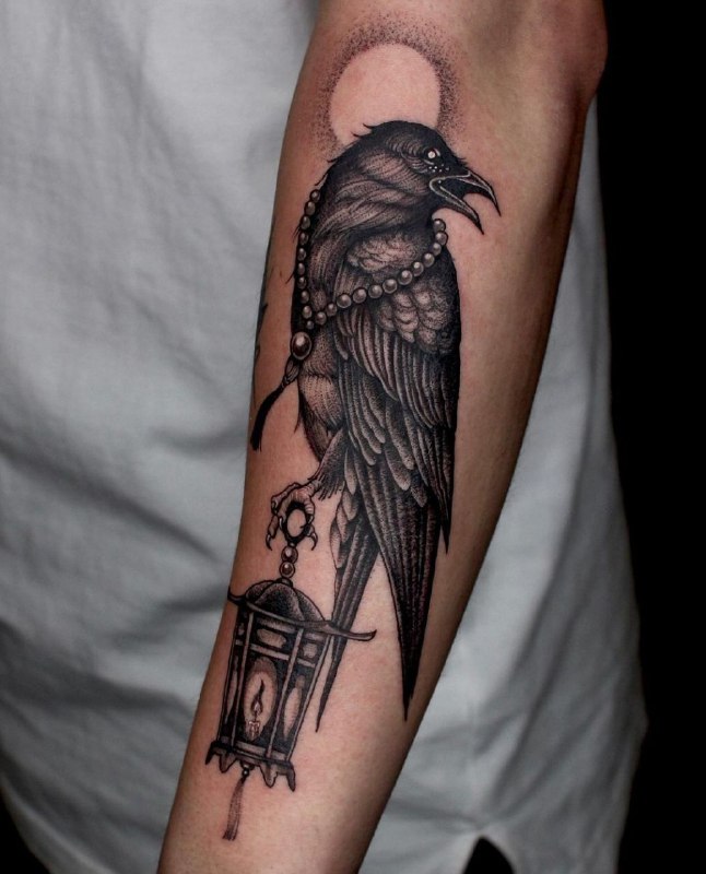 Large tattoo of a raven on the forearm for men