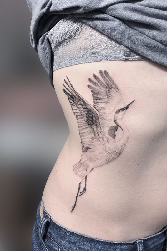 Large crane tattoo on the side for women