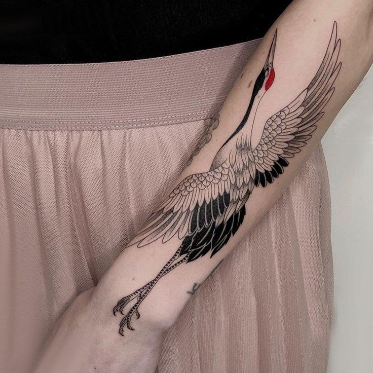 Large crane tattoo on the arm for women