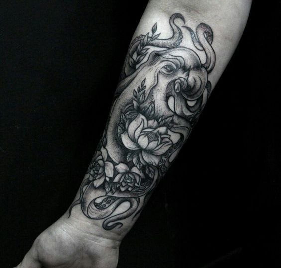 Octopus tattoo with flowers on the forearm for men