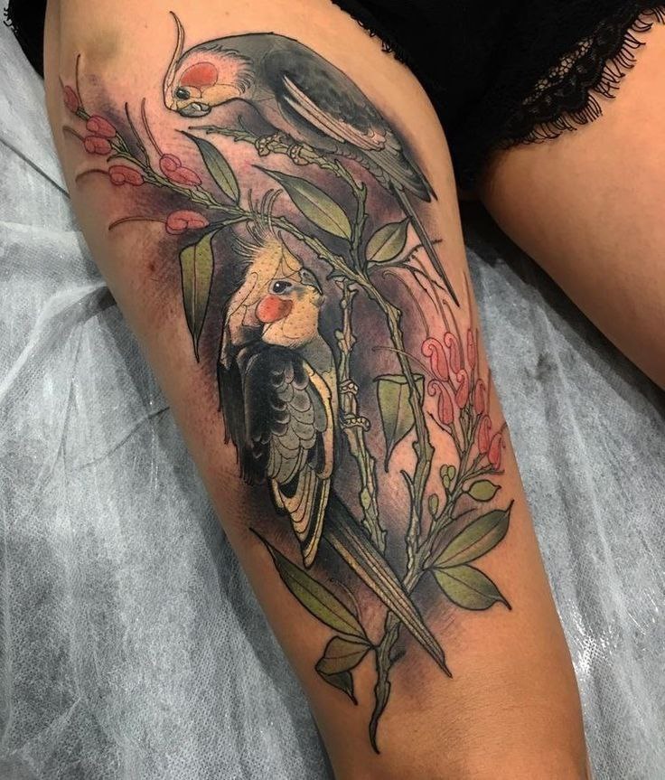 Large tattoo of two parrots on the thigh for women