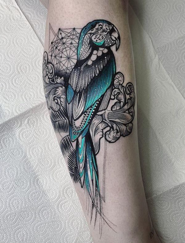 Colored parrot tattoo on the shin for women