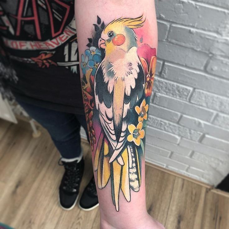 Large parrot tattoo on the forearm for women