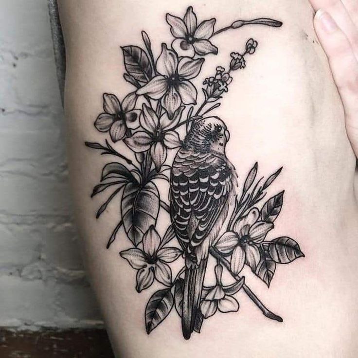 Parrot tattoo with flowers on the leg for women