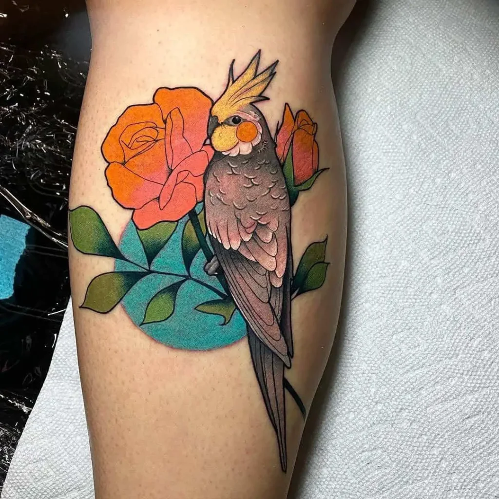 Colorful parrot tattoo with a rose on the calf for women