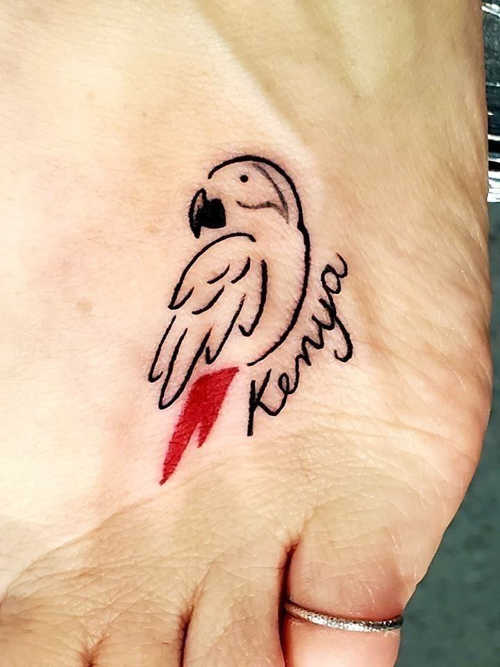 Small parrot tattoo with an inscription on the ankle for women