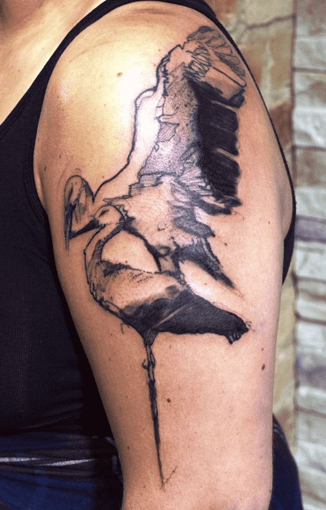 Large tattoo of two storks on the shoulder for men