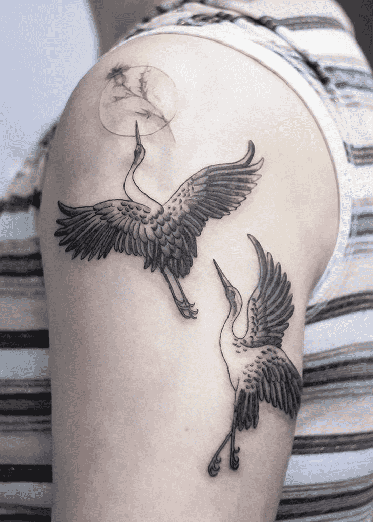 Tattoo of two storks on the shoulder for women