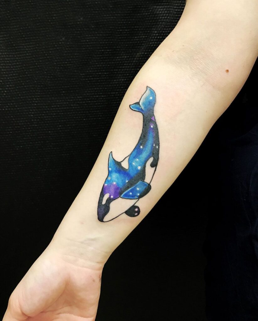 Colored orca tattoo on the forearm for women