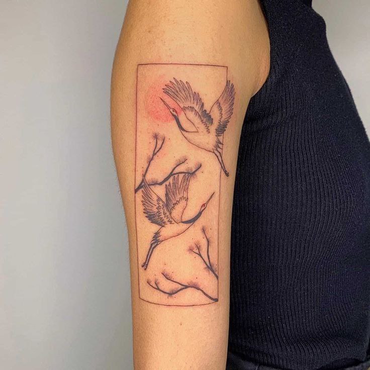 Large tattoo of two cranes on the shoulder for men