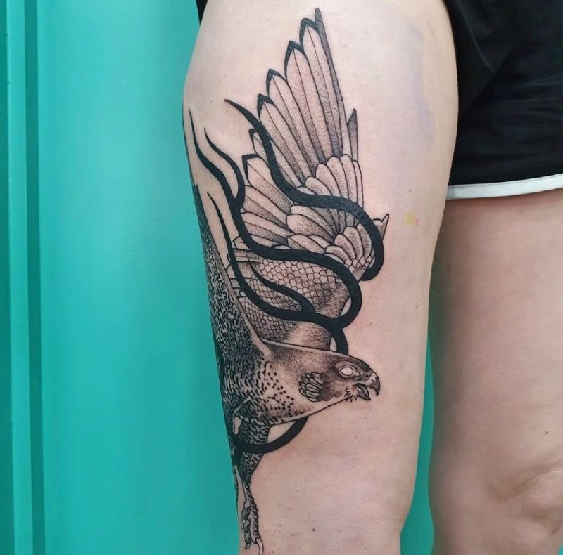 Large falcon tattoo on the thigh for women