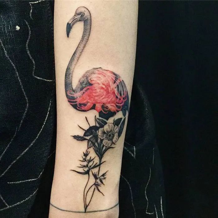 Large flamingo tattoo with flowers on the arm for women