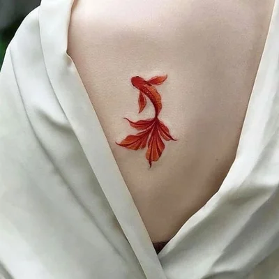 Colorful goldfish tattoo on the back for women