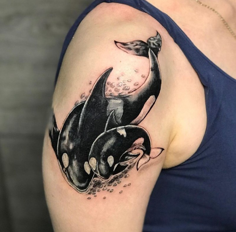 Large tattoo of two orcas on the shoulder for men