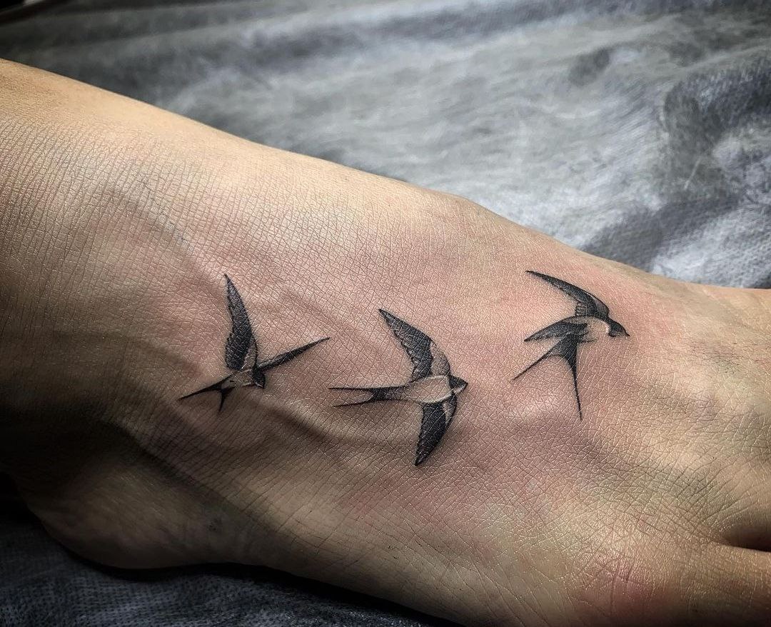 Tattoo of three swallows on the ankle for men