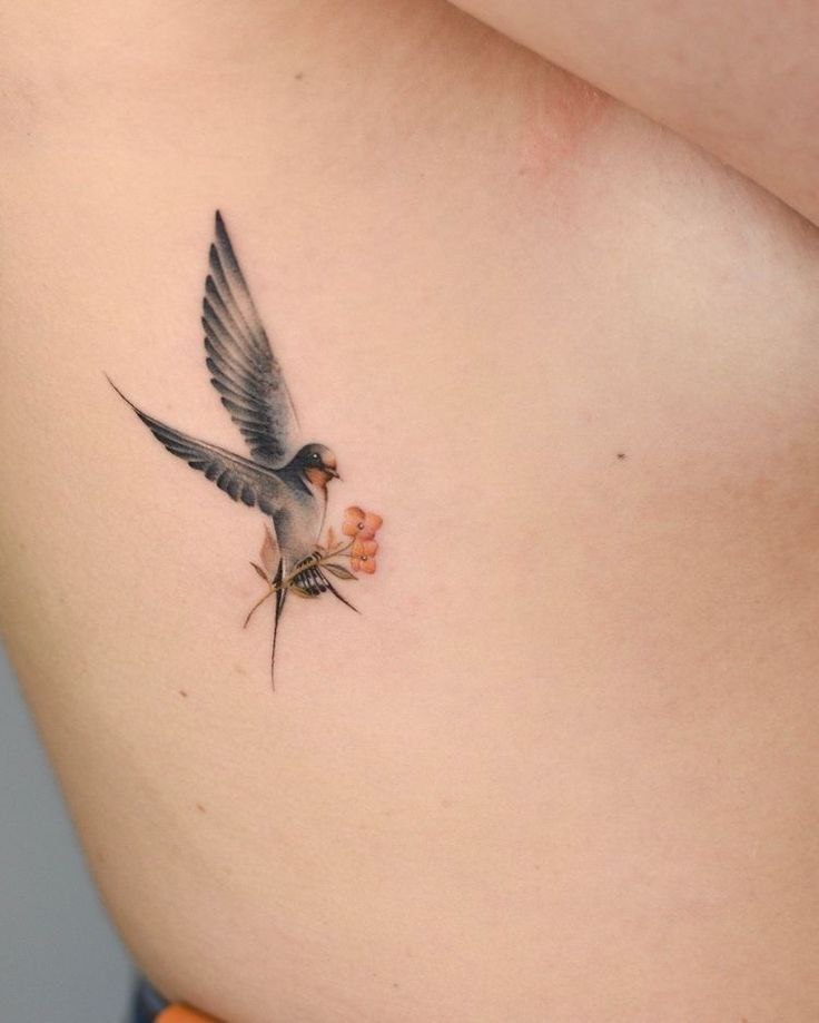 Color swallow tattoo on the side for women