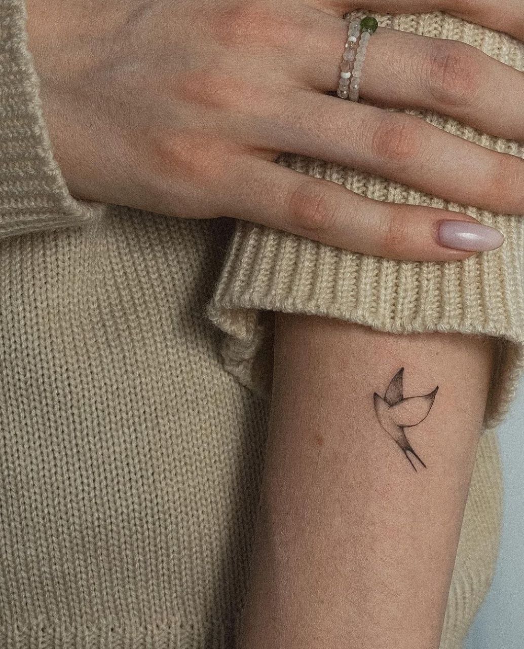 Small tattoo of a swallow on the shoulder for women