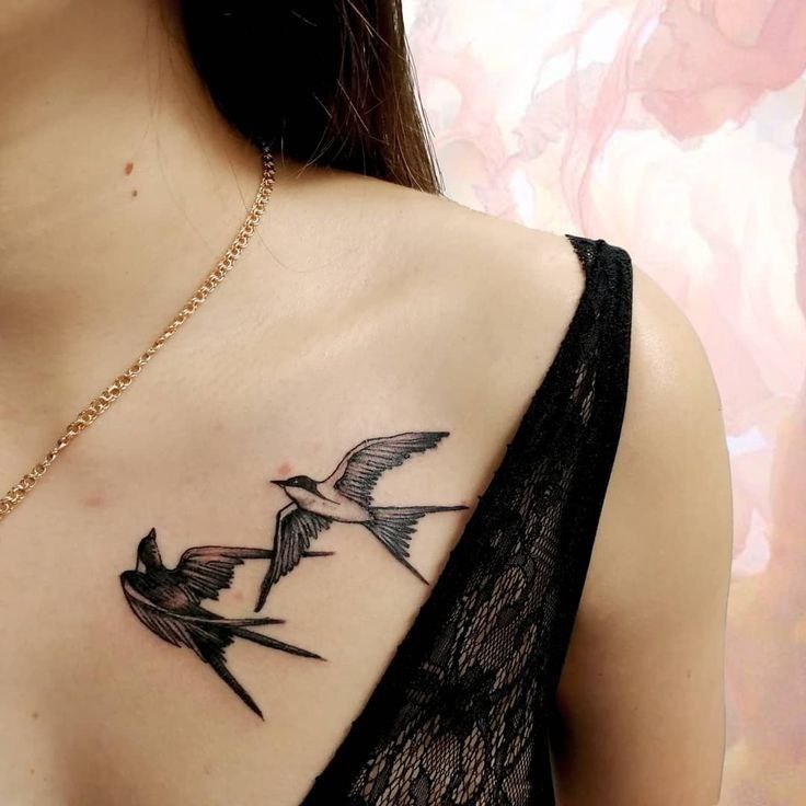 Tattoo of two swallows on the collarbone for women