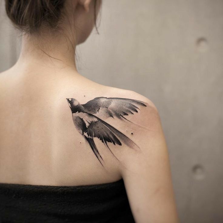 Large swallow tattoo on the shoulder blade for women