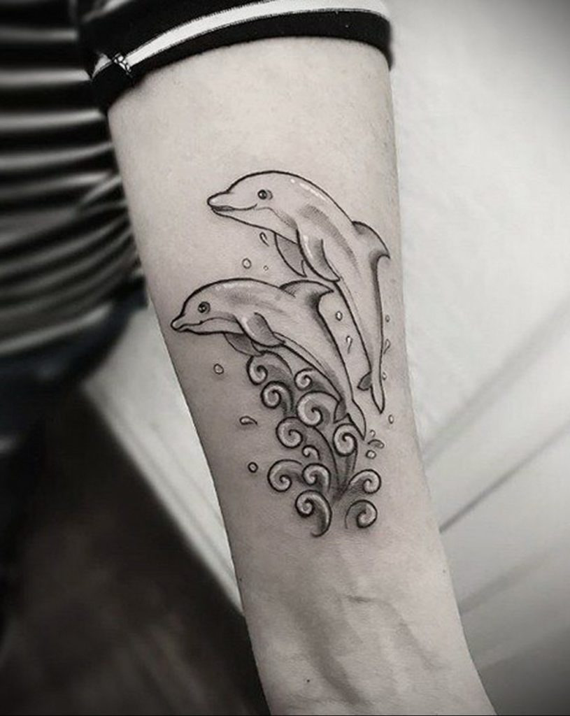 Tattoo of two dolphins on the shoulder for women