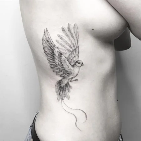 Tattoo of a dove on the side for women