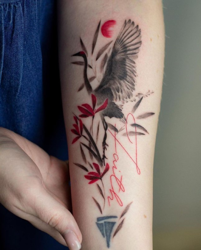 Color tattoo of two storks with an inscription on the arm for women