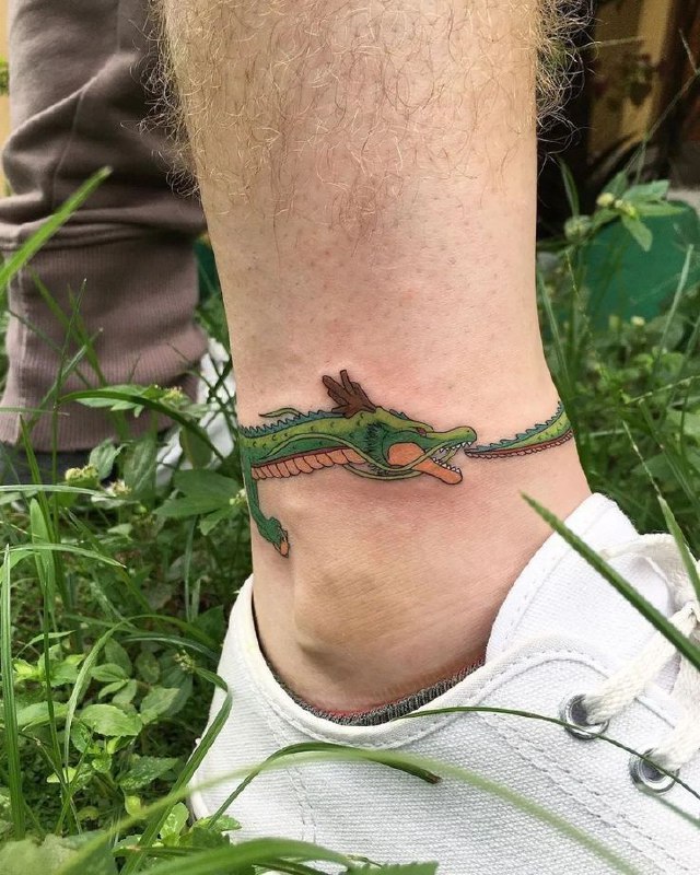 Uroboros tattoo on the ankle for men